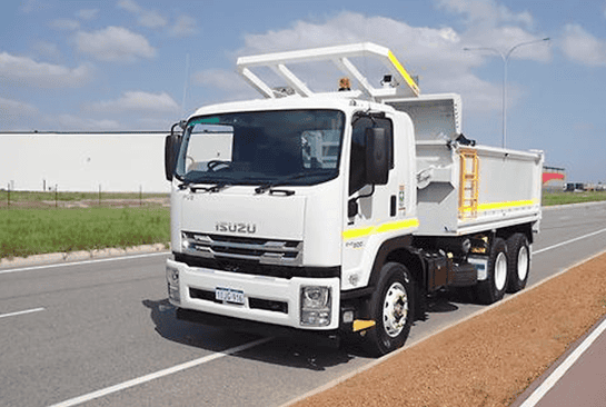 Heavy-duty Isuzu truck used for construction and industrial equipment rental by Miniquip Hire, parked on a road with a clear sky.